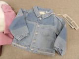 a blue jean jacket and a pink hat on the floor