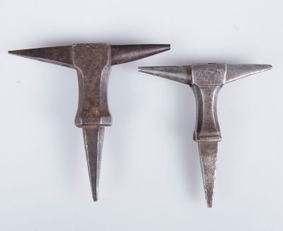 pair of antique hammers on a white surface with a white background