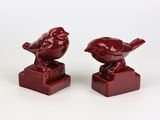 deux petits oiseaux rouges perchés l'un sur l'autre