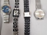 several different watches are lined up on a white surface
