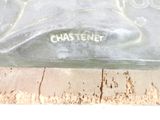 a glass bottle with a dog on it sitting on a piece of wood