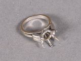 silver ring with a horse and rider on it on a gray surface