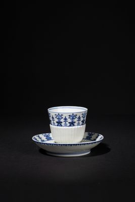 blue and white cup and saucer on a black background