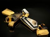 deux bijoux dorés et noirs posés sur une surface noire