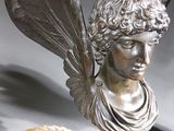 a statue of a woman with wings on top of a table