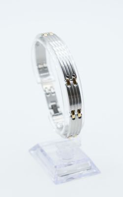 a close up of a silver and gold bracelet on a clear stand