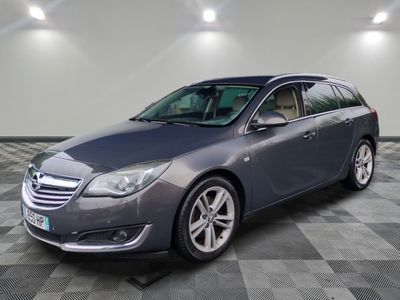 the grey opel is parked in a room with a checkered floor