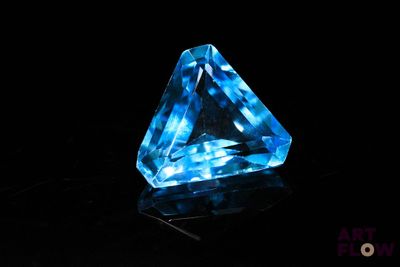 gros plan d'un diamant bleu sur une surface noire