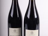 deux bouteilles de vin posées l'une à côté de l'autre sur une surface blanche