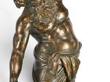 bronze statue of a man with a beard holding a book