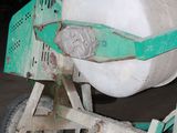 a cement mixer sitting on a dolly in a garage