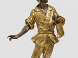 une statue représentant un homme tenant un lustre posé sur une table