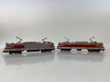 two toy trains sitting side by side on a white surface