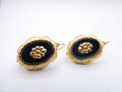 pair of black and gold earrings with flower design