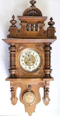 a wooden clock on the wall with a bird on it