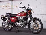 a red motorcycle parked in front of a white brick wall