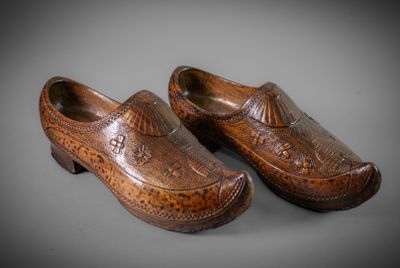 pair of carved wooden clogs on a gray surface