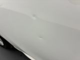 a close up of a white car with scratches on it ' s hood