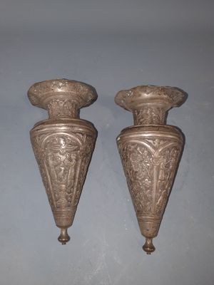 deux vases en argent posés l'un à côté de l'autre sur une table