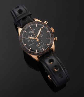 a close up of a watch on a black surface