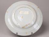 a white plate on a metal stand with a tag on it