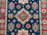 a blue and red rug with a diamond design on it