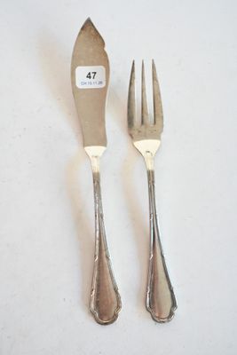 une paire de fourchettes et de cuillères plaquées argent posées sur une surface blanche