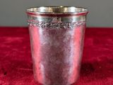 a silver cup on a red cloth