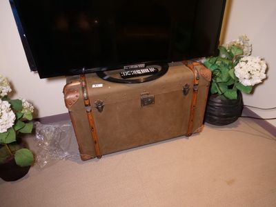 une valise posée sur une autre valise, avec une télévision dessus