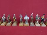sept figurines représentant des hommes à cheval, montées sur des socles en bois