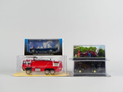 Deux camions de pompiers rouges sont garés l'un à côté de l'autre sur une surface blanche.