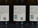 three bottles of wine sitting on a table with a qr code on the label