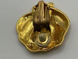 a close up of a gold object on a white surface