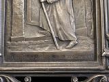a metal plaque with a picture of a man holding a staff