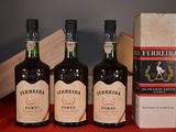 three bottles of wine sitting on a table next to a box of cigarettes