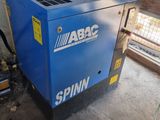 a blue air compressor sitting in a room next to a window