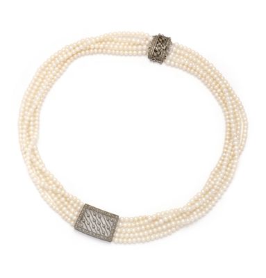 un gros plan sur un collier orné de perles et muni d'un fermoir en argent