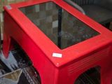 a red table with a glass top in a living room