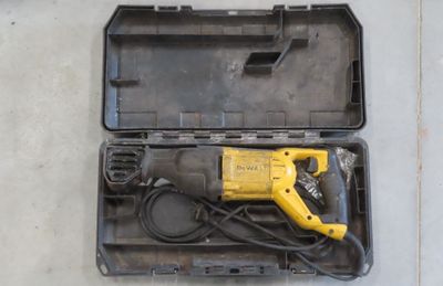 a yellow and black drill in a case on the floor