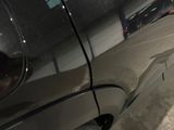 a close up of a car ' s side door with a reflection of a person in the window