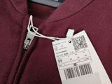a close up of a maroon sweater with a price tag on it