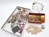 une boîte remplie de bijoux variés posée sur une surface blanche