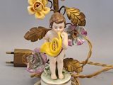 a figurine of a girl holding a flower on top of a table