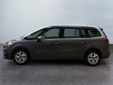 grey minivan parked in a parking lot on a cloudy day