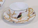 a cup and saucer with a bird design on it