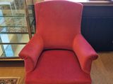 a red chair that is sitting in front of a window