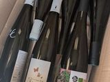 six bouteilles de vin dans un carton posé par terre