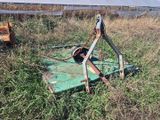 une tondeuse à gazon verte au milieu d'un champ