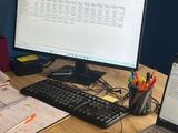 a man that is sitting at a desk with a laptop and a monitor