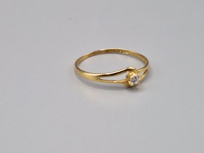 gros plan d'une bague en or sur une surface blanche